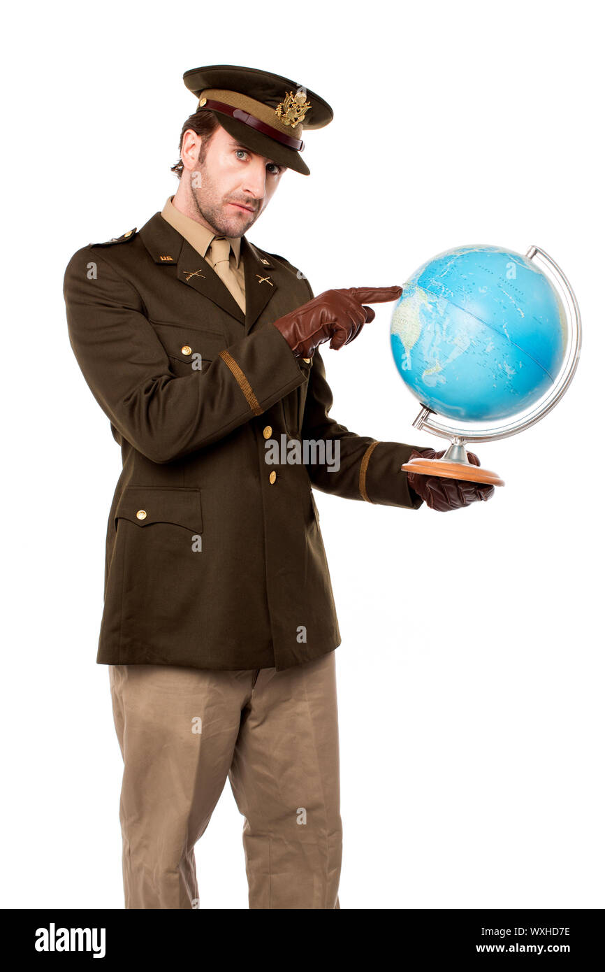 Giovane ufficiale militare azienda mappa del globo e indicante Foto Stock