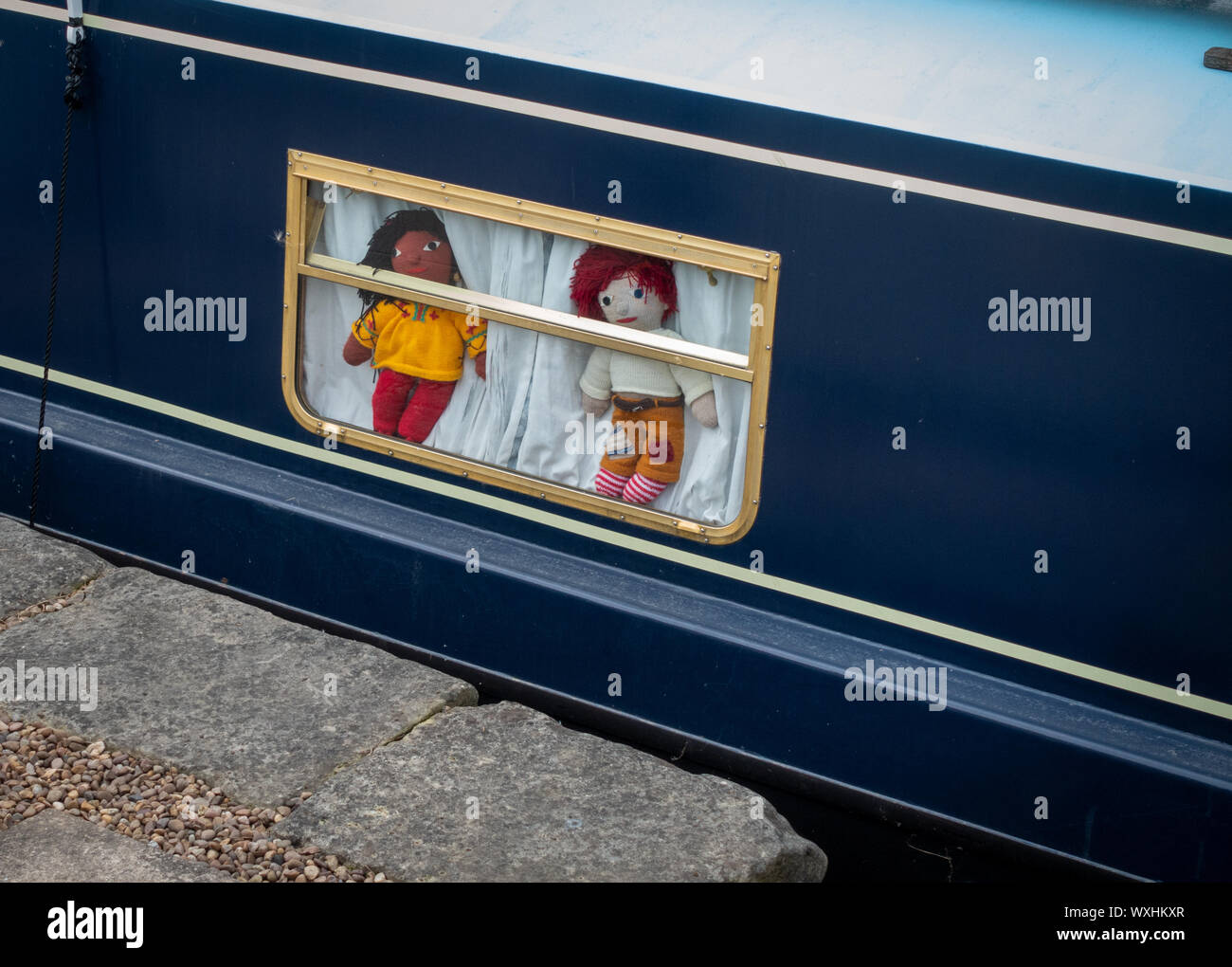 Rosie e Jim bambole a maglia nella finestra Narrowboat Foto Stock