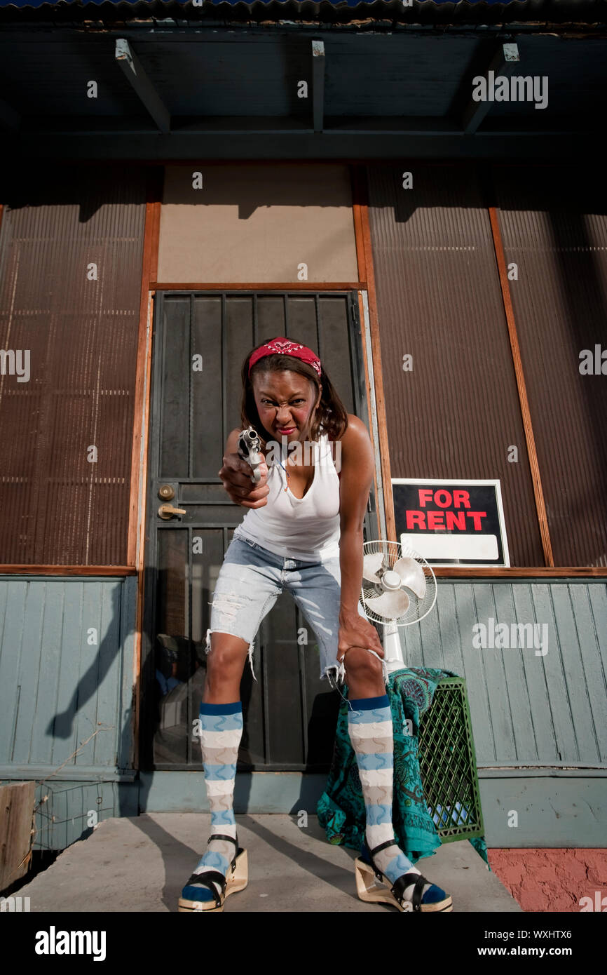 African American donna con una pistola sul suo portico anteriore Foto Stock