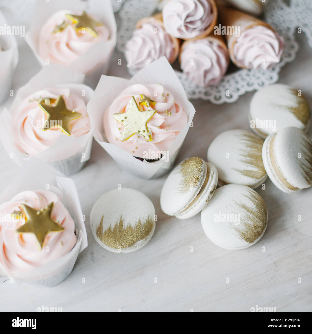 Tortini, coni di cialda con panna e amaretti con oro decorazioni colorate Foto Stock