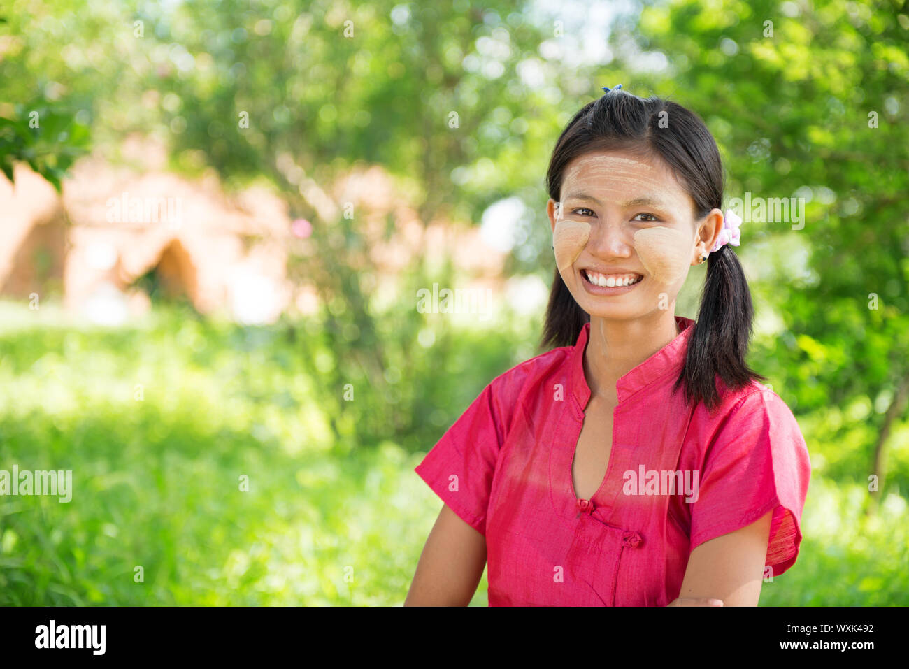 Ritratto di sorridenti giovane e bella tradizionale ragazza del Myanmar in piedi all'aperto. Foto Stock