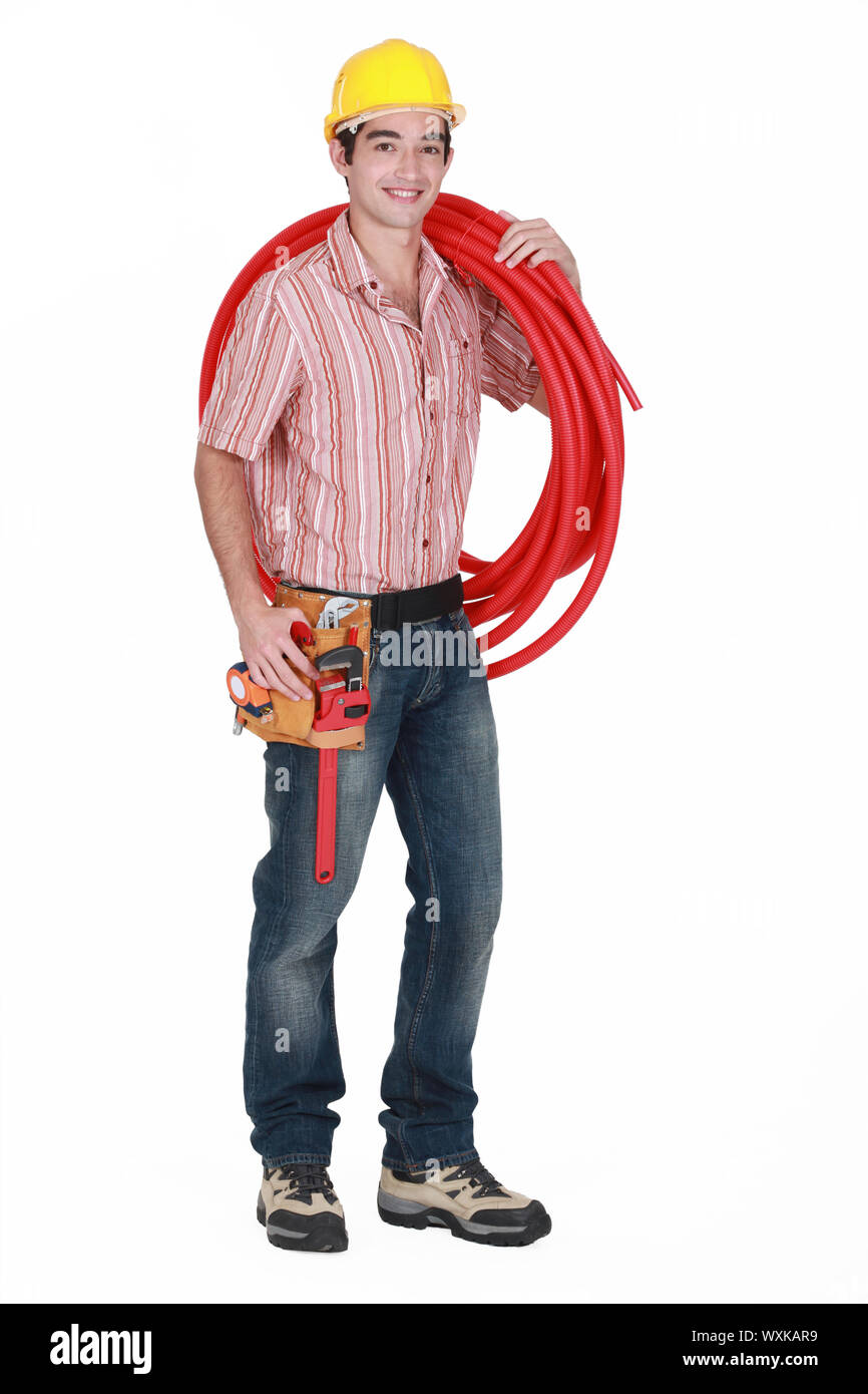 Giovani tradesman portando il tubo ondulato Foto Stock