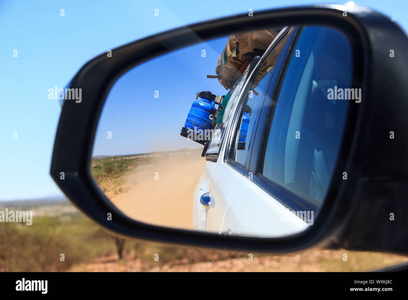 Guardare nel retrovisore, la guida su una strada di sabbia in Namibia Foto Stock