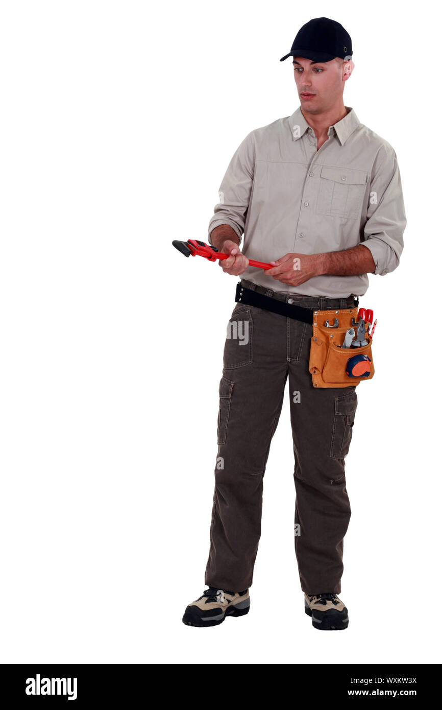 Stupito uomo in possesso di una chiave a tubo Foto Stock