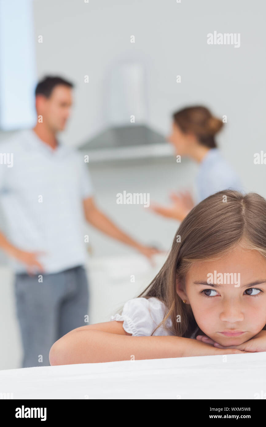 Sconvolto bambina ascoltando i genitori che stanno sostenendo in cucina Foto Stock