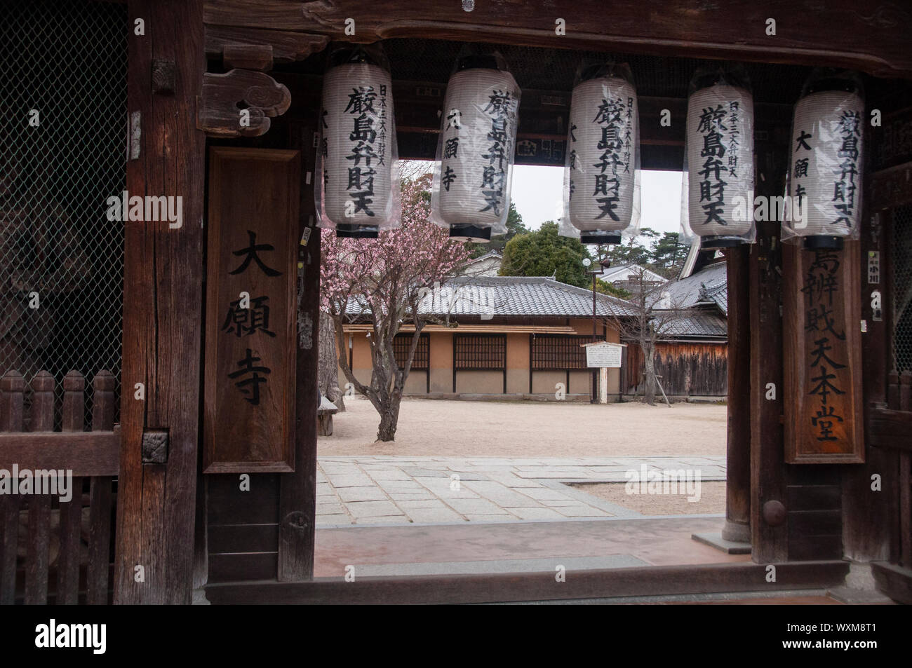 L'architettura giapponese, realizzata a mano in legno, incornicia un cortile a Miyajima. Foto Stock