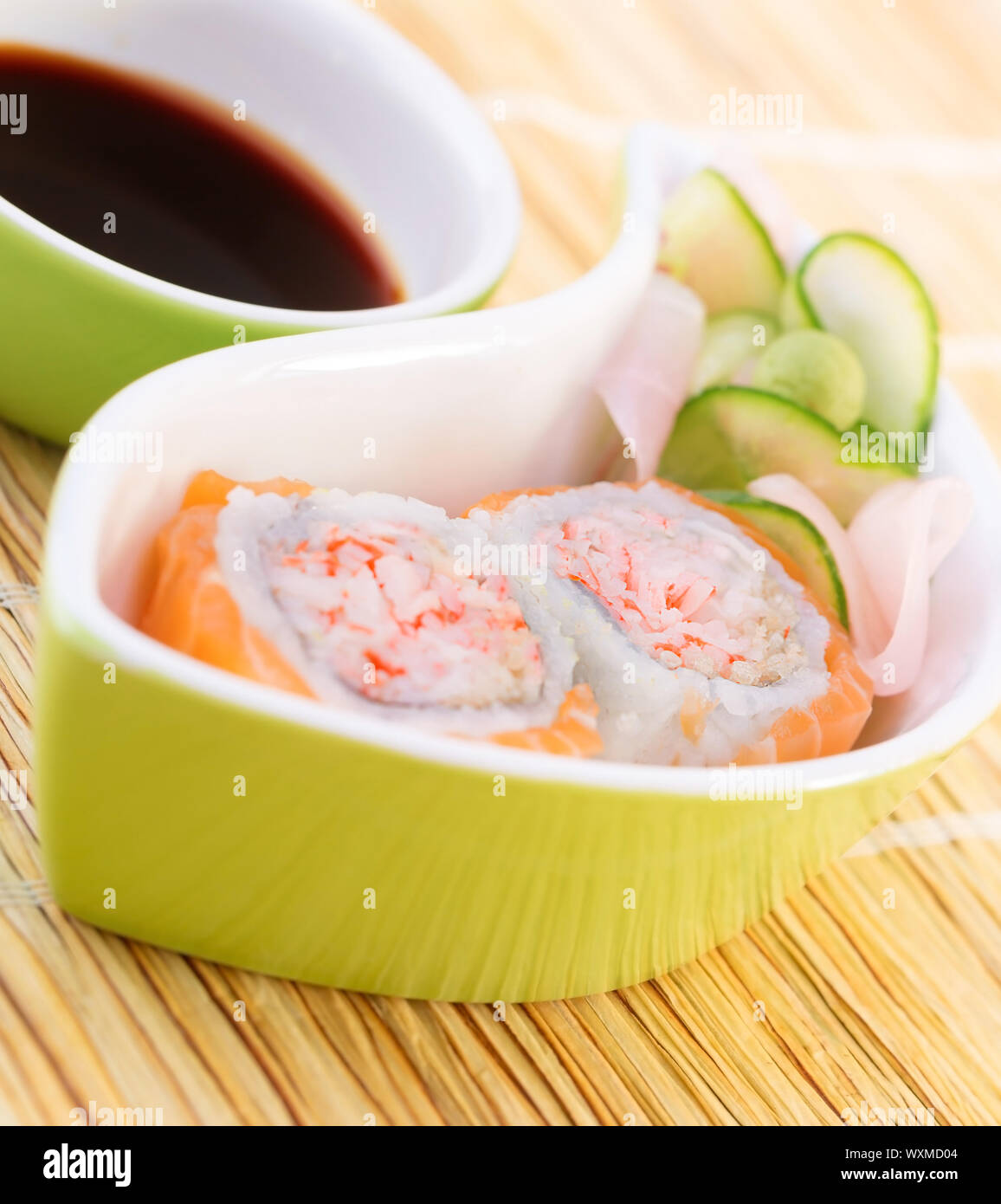 Gustosi piatti sushi con salsa di soia sul tavolo, delizioso rotolo con polpa di granchio e salmone crudo, cibo asiatico, decorato con il cetriolo e zenzero, lusso mangiare c Foto Stock