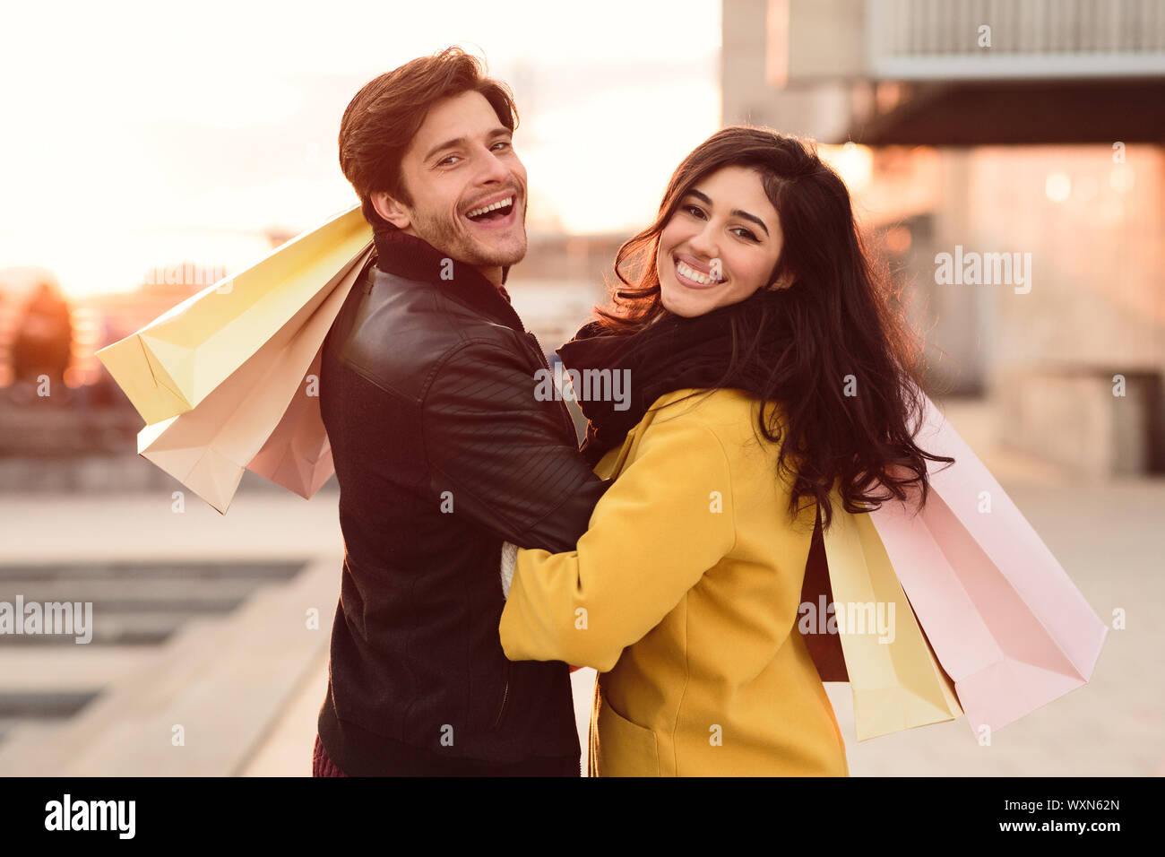Happy sposi novelli il trasporto delle borse della spesa e sorridente alla fotocamera Foto Stock