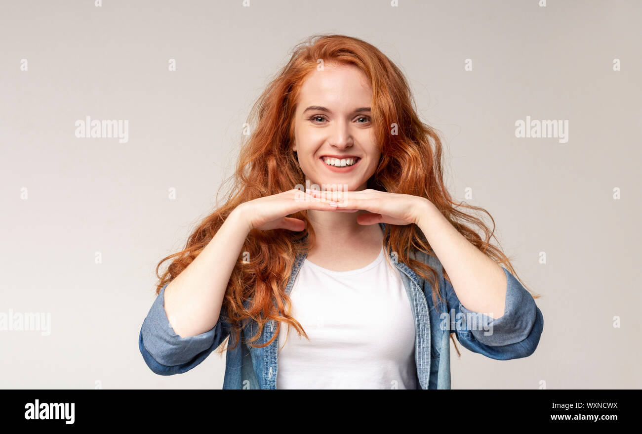 Ritratto di felice redhead girl mento pendente sul suo palms Foto Stock