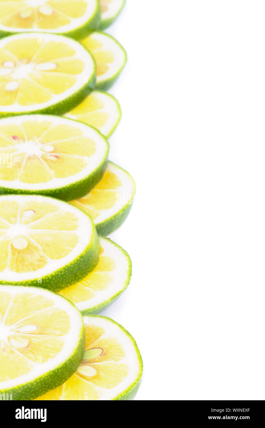 Telaio di verdi maturi fette di limone closeup su sfondo bianco Foto Stock