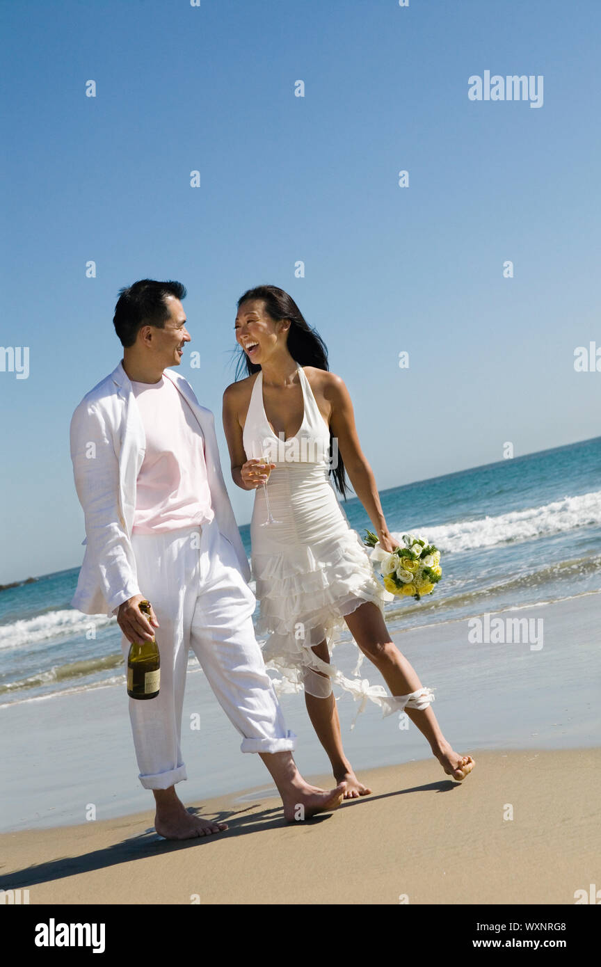 Sposa e lo Sposo camminando sulla spiaggia Foto Stock