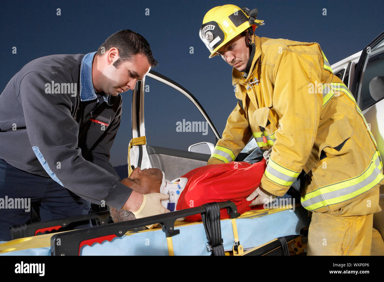 I Vigili del fuoco e paramedici che assistono ad un crash di Vista Foto Stock