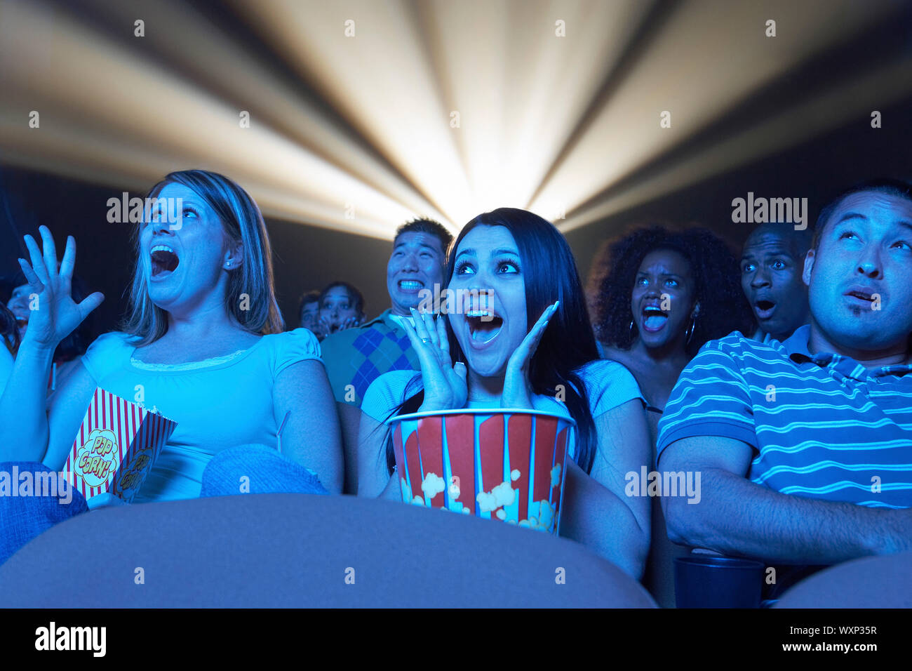 Persone che guardano film horror in teatro Foto Stock