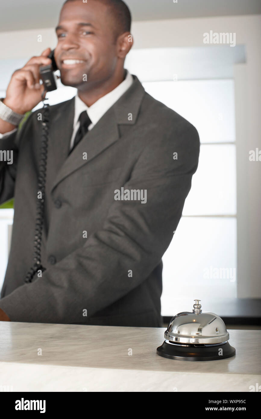 Imprenditore sul telefono alla Reception Foto Stock