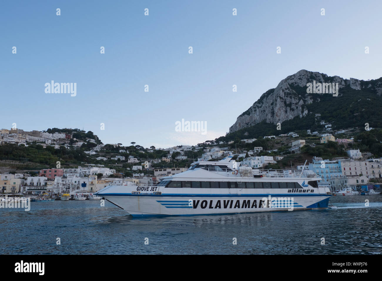 Ferry boat lasciando Marina grande sull'Isola di Capri al tramonto in estate Italia Foto Stock