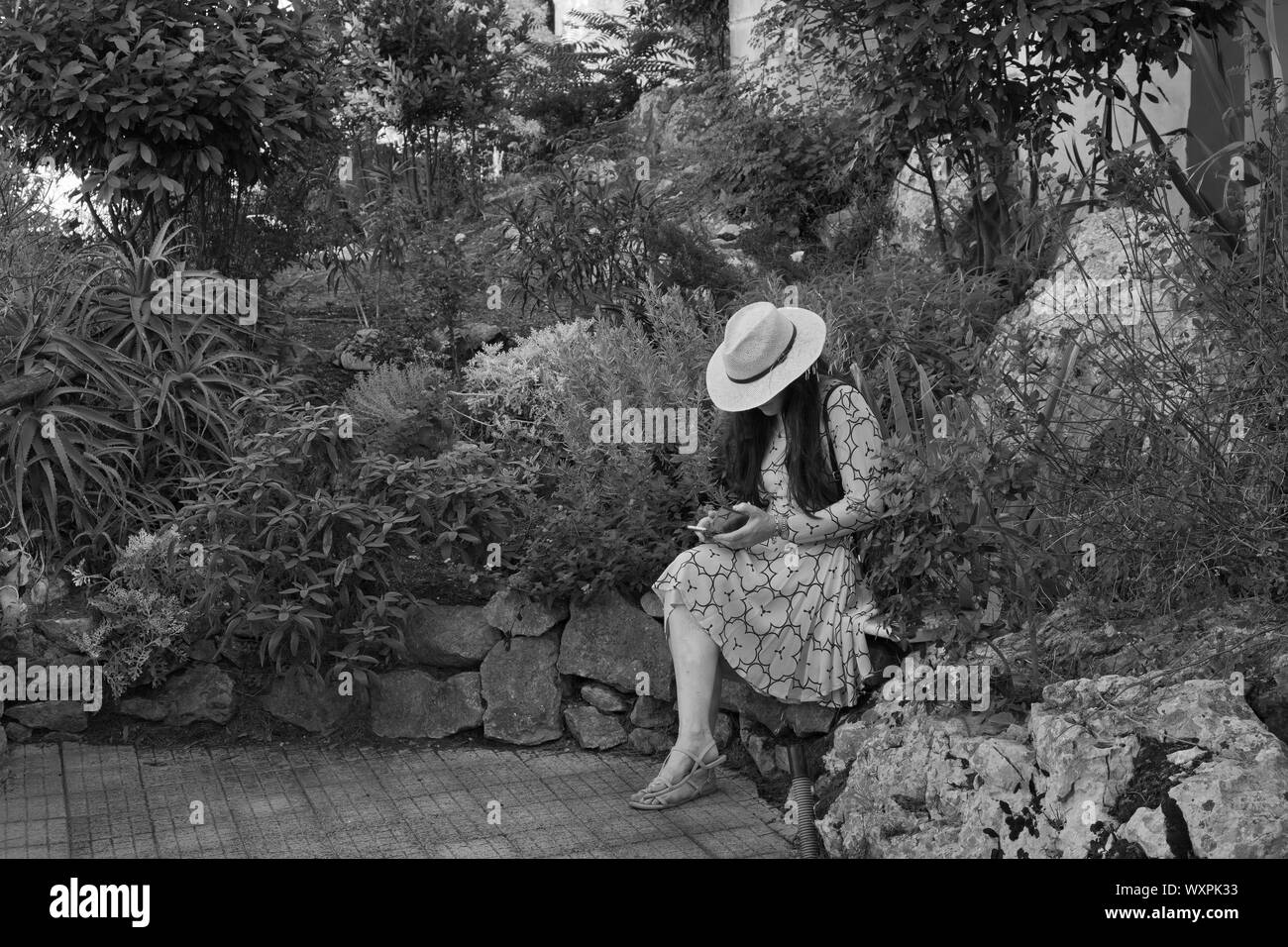 Donna seduta nei giardini di Villa Lysis home di Jacques Fersen nell'isola di Capri in estate Itay Foto Stock