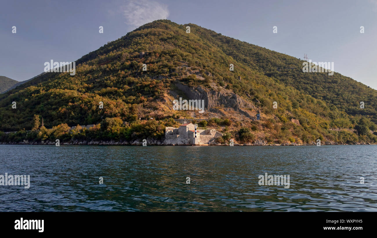 Baia di Kotor, Montenegro - Vista dal mare del faro e la vecchia chiesa di Nostra Signora dell'Angelo (Gospa od Andjela) Foto Stock