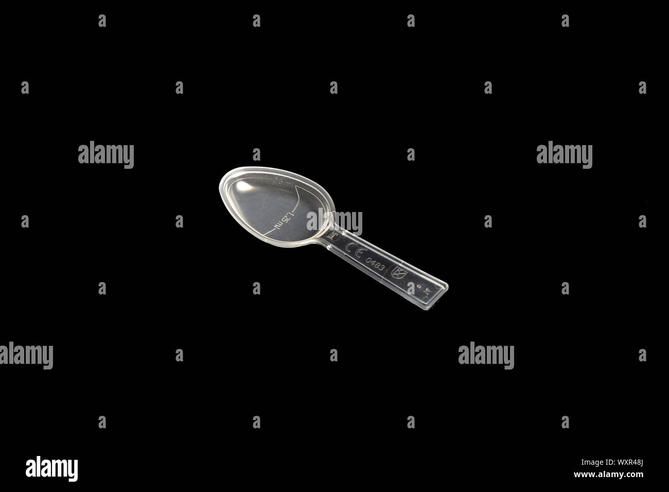 Un unico, chiaro, medicina cucchiaio di dosaggio isolato su sfondo nero Foto Stock
