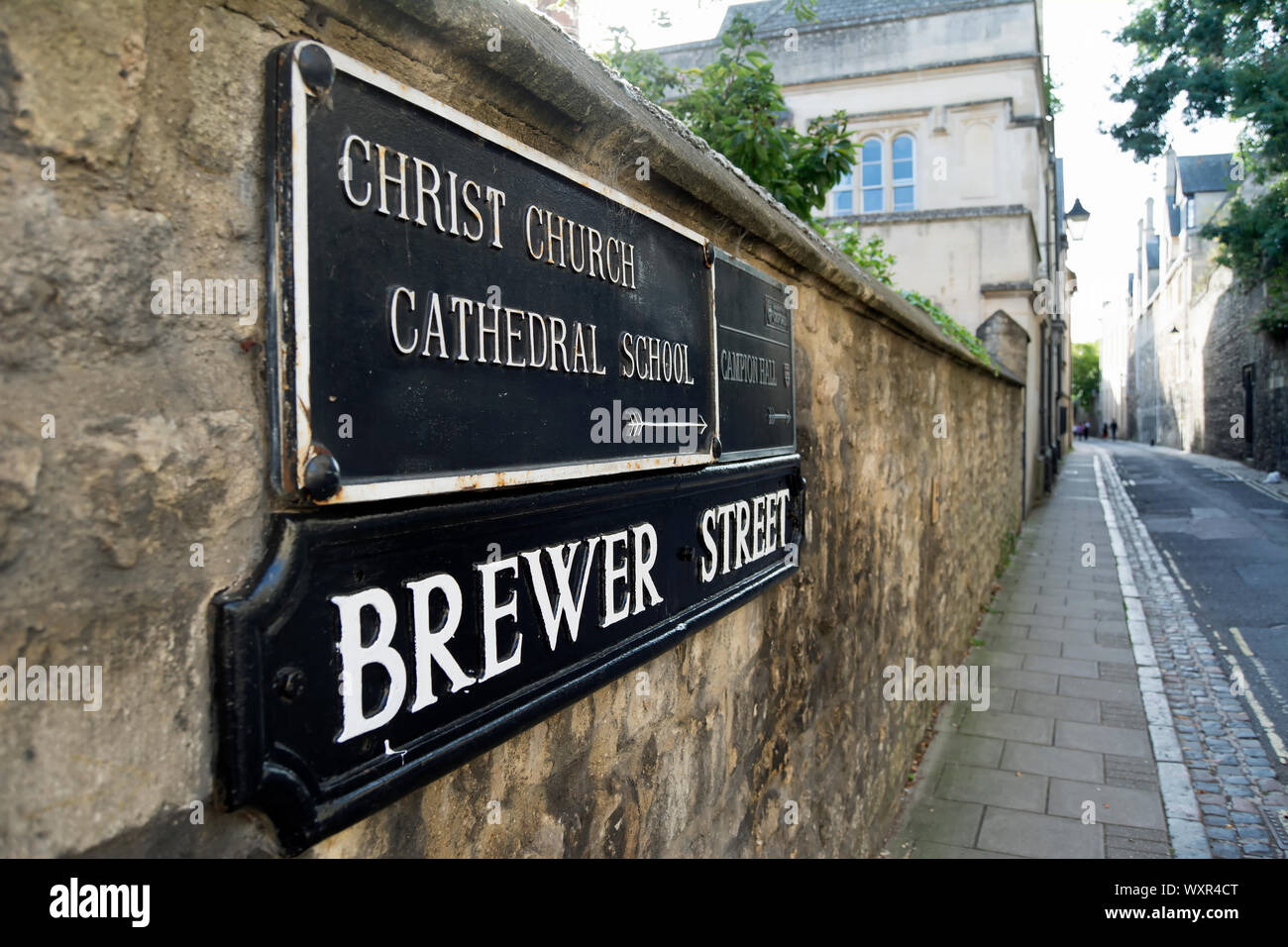 Il nome della strada segno per Brewer street, oxford, inghilterra, sotto la direzione di un segno per la Chiesa di Cristo Scuola cattedrale Foto Stock