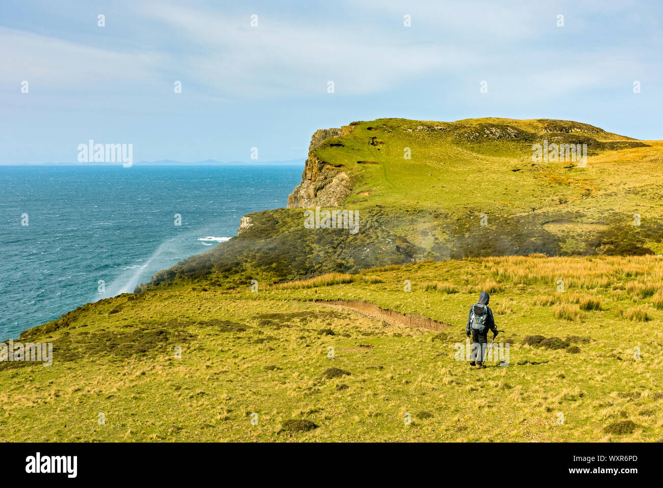 Un viandante si avvicina il promontorio di Rubha Cruinn con spray da Allt Mheididh cascata, Talisker Bay, Minginish, Isola di Skye, Scotland, Regno Unito Foto Stock