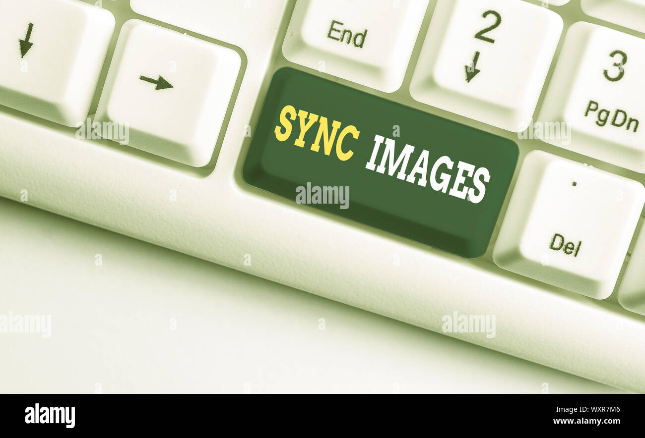Conceptual la scrittura a mano che mostra le immagini di sincronizzazione. Concetto significato rendendo le foto identiche in tutti i dispositivi accessibili ovunque bianco tastiera PC con nota pa Foto Stock