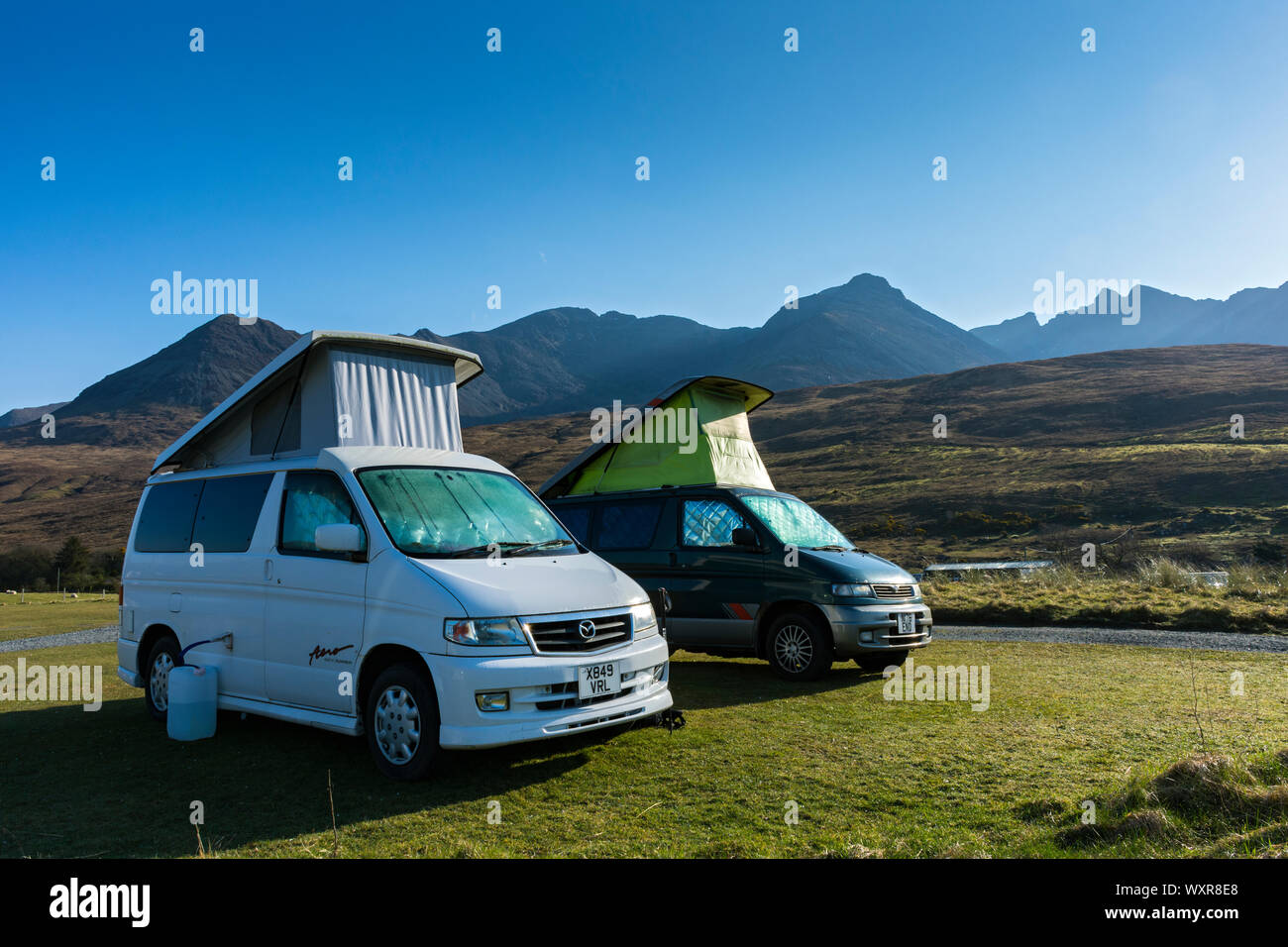 Due Mazda Bongo camper nel campeggio a Glen fragile con le montagne Cuillin dietro. Minginish, Isola di Skye, Scotland, Regno Unito Foto Stock