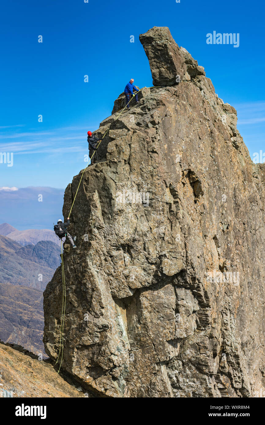 Gli alpinisti la discesa in corda doppia off inaccessibile di Pinnacle, in occasione del vertice di Sgurr Dearg, montagne Cuillin, Minginish, Isola di Skye, Scotland, Regno Unito Foto Stock