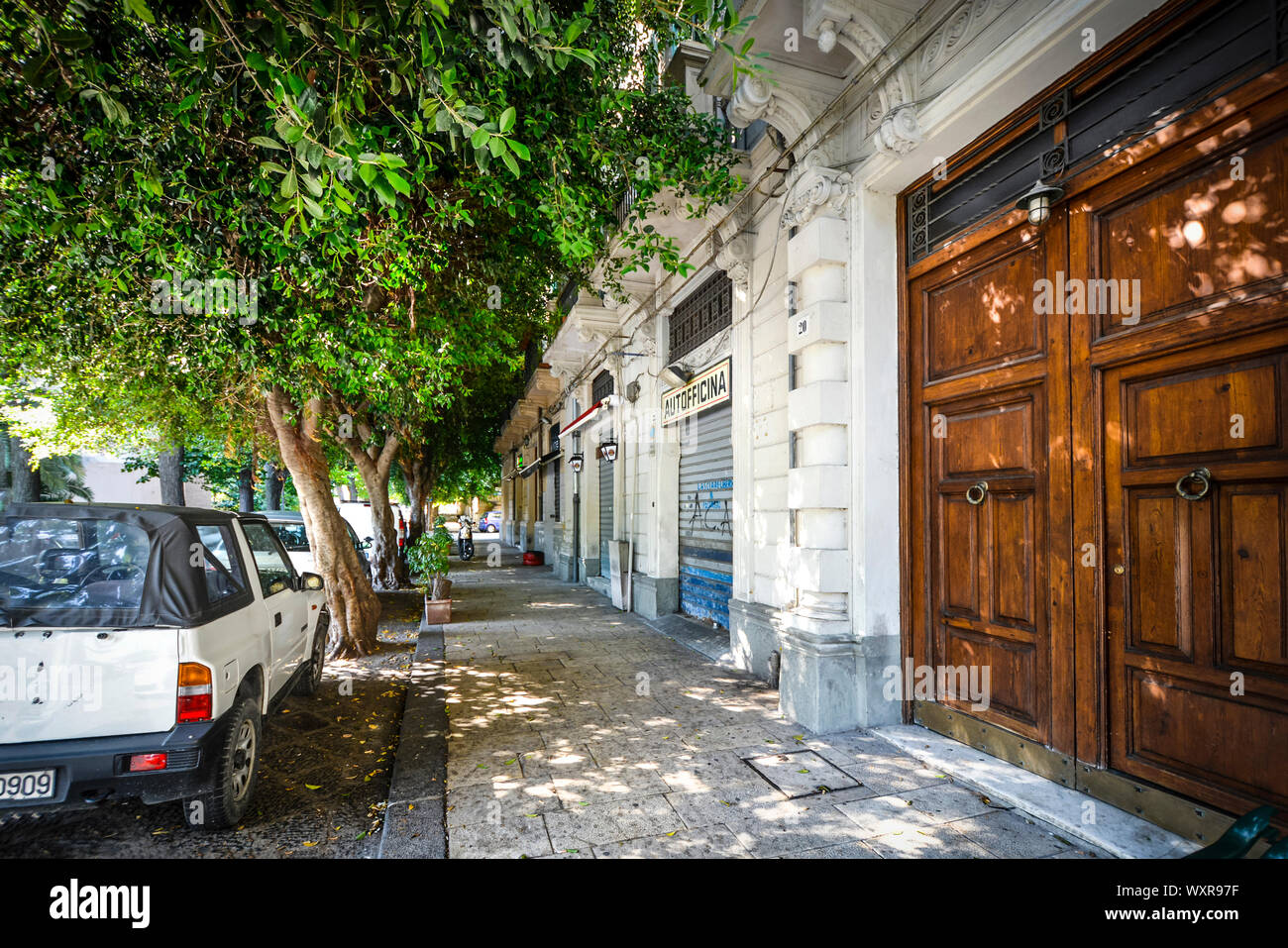 Un ombreggiato street nella città di Messina Italia sull'isola di Sicilia. Foto Stock