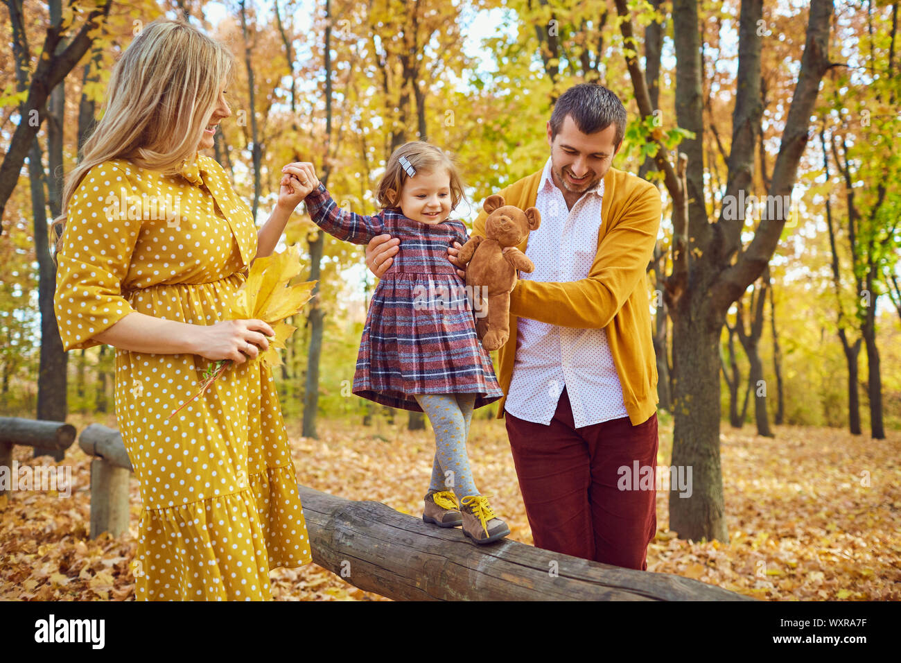 La famiglia gioca con la loro figlia su la natura in autunno Foto Stock