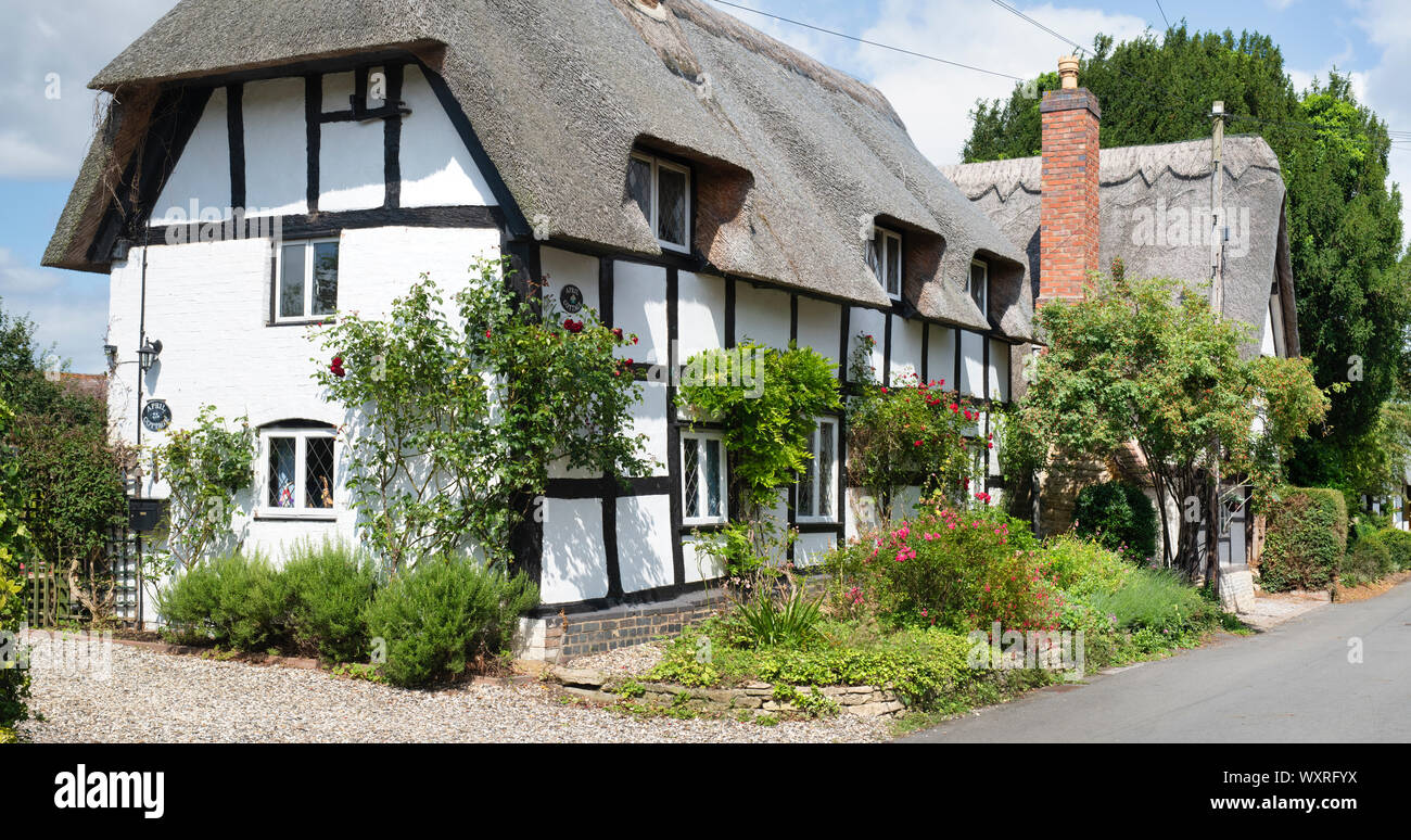 Con il tetto di paglia in bianco e nero con cornice in legno cottage lungo manor lane. Poco Comberton , Cotswolds, Wychavon district, Worcestershire, Regno Unito Foto Stock