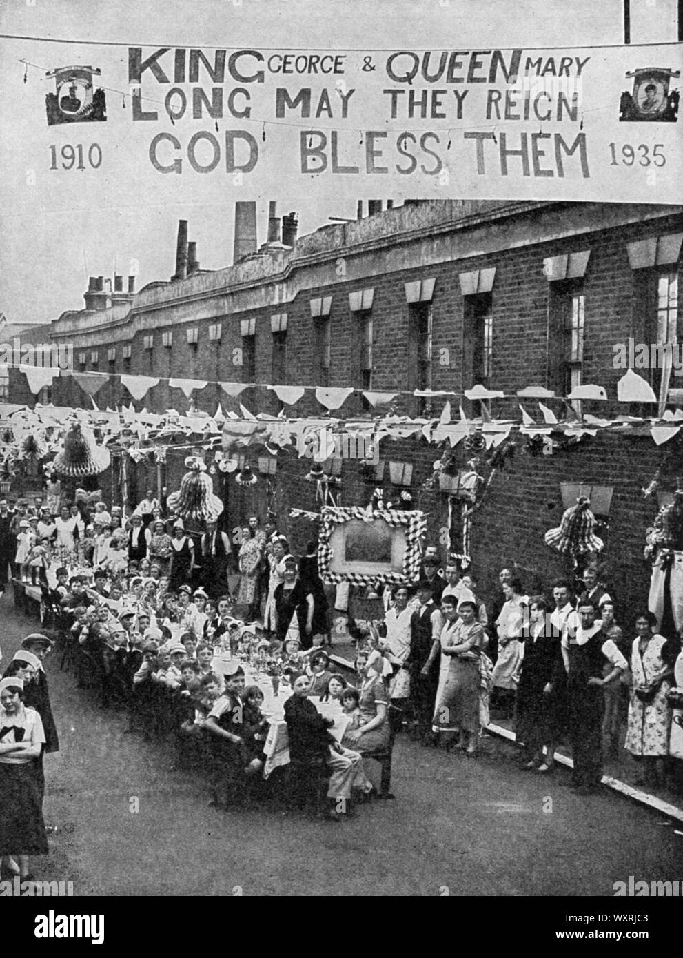 Street party, Palace Road, nell'East End di Londra, 1935. Una street party per celebrare il Giubileo d'argento del re George V. Foto Stock