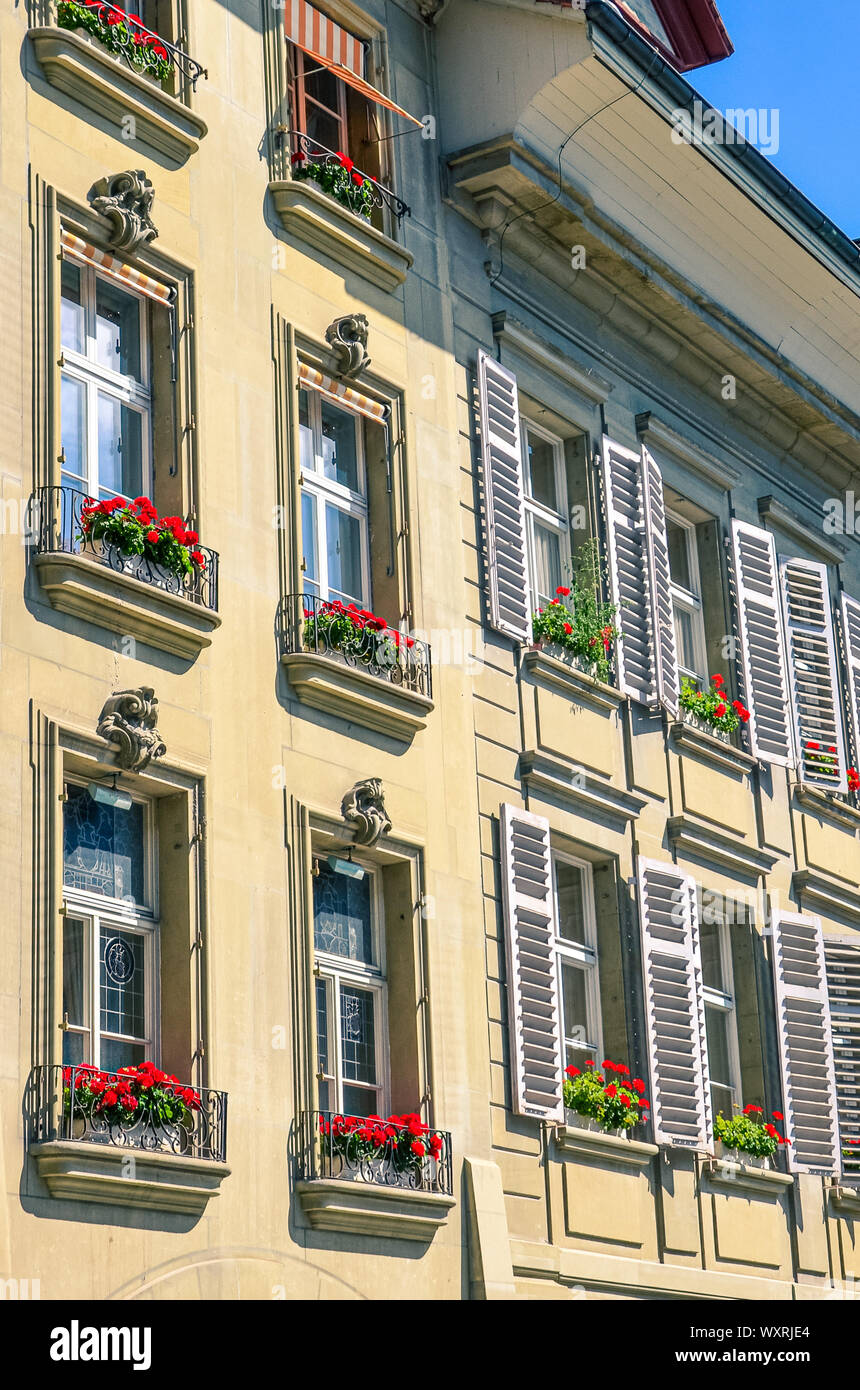 Bella facciata di un edificio storico di Berna, Svizzera. Decorate con fioriere con tradizionale rosso fiori di geranio. Capitale della Svizzera. Fiore tipico della decorazione. L'esterno degli edifici. Foto Stock