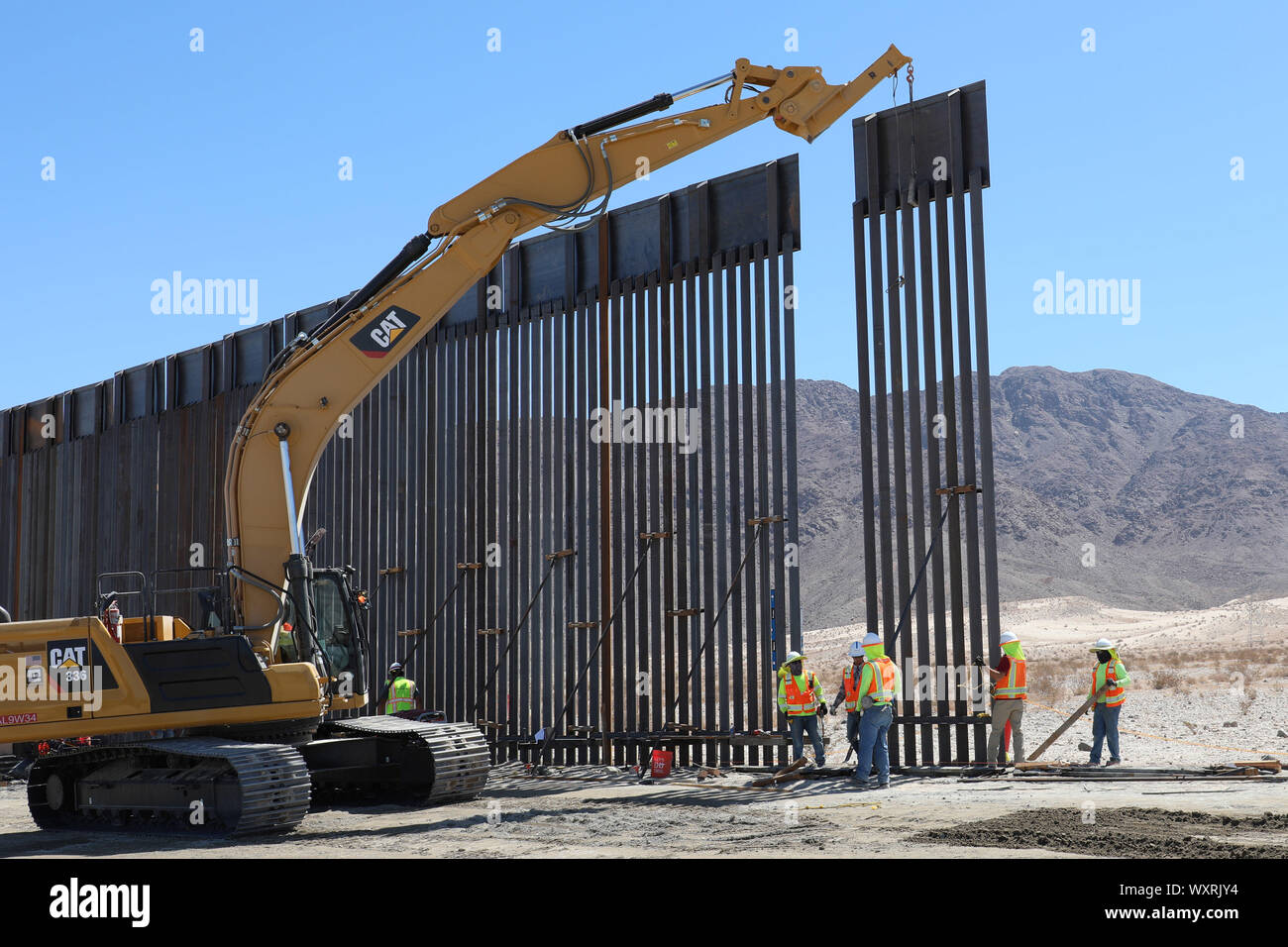 Un U.S. Esercito di ingegneri contraente utilizzi un escavatore per abbassare un acciaio bollard pannello di barriera in posizione nei pressi di El Centro in California, Sett. 12, 2019. Questi progetti sono in corso di esecuzione da USACE, come diretto attraverso gli Stati Uniti Esercito dal Segretario della Difesa, in risposta al Dipartimento di Sicurezza della richiesta di assistenza per proteggere gli Stati Uniti frontiera meridionale bloccando i trafficanti di droga nei corridoi attraverso la costruzione di strade e di recinti, e l'installazione dei dispositivi di illuminazione sotto il titolo 10, Sezione 284 DEGLI STATI UNITI Codice. E DoD USACE sono esecuzione di questi progetti di sostegno Foto Stock