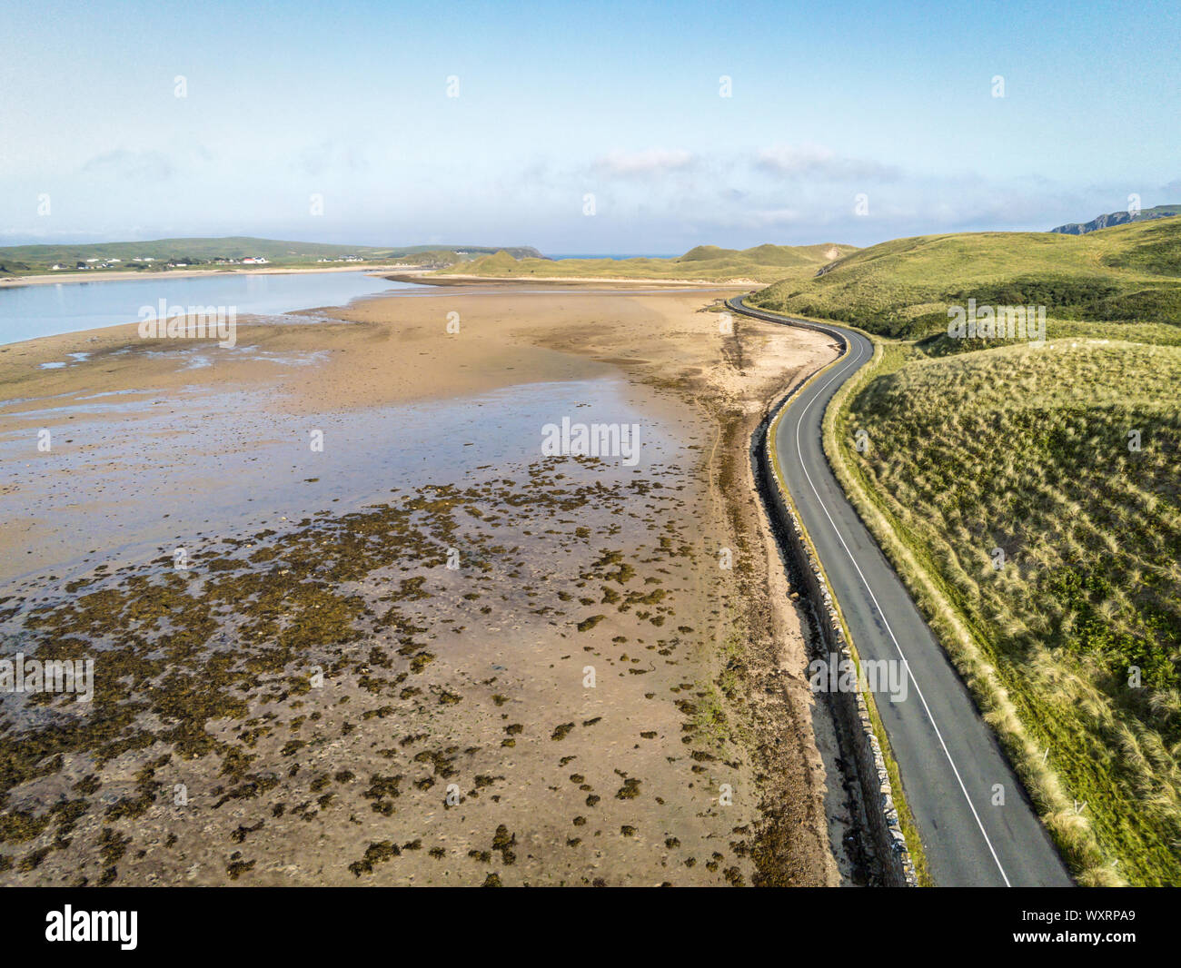 Una strada costiera a bassa marea nella contea di Donegal Irlanda Foto Stock