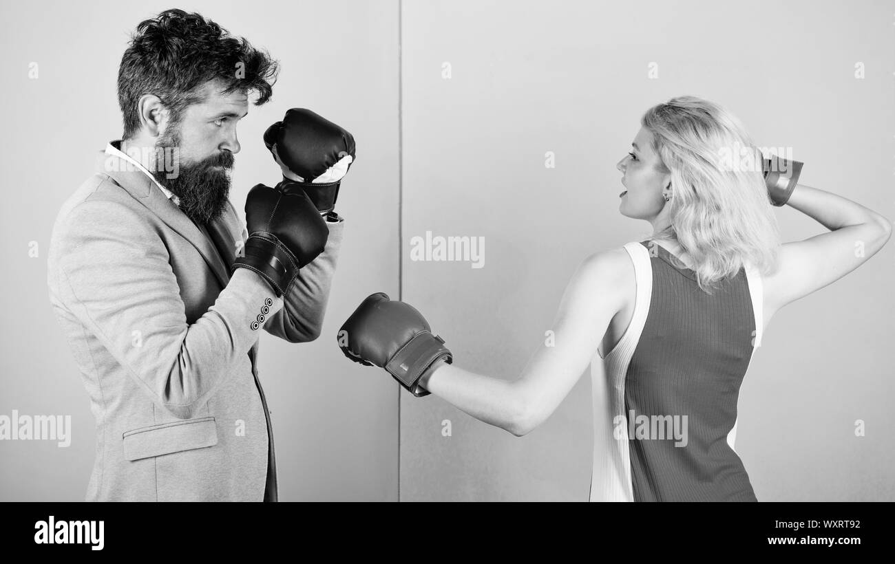 La parità tra i sessi. Uomo abito formale e atletico donna boxe lotta. Matura in amore competere nel pugilato. Maschi e femmine di boxer combattimenti a guanti. Concetto di dominazione. Battaglia di genere. Sesso parità di diritti. Foto Stock