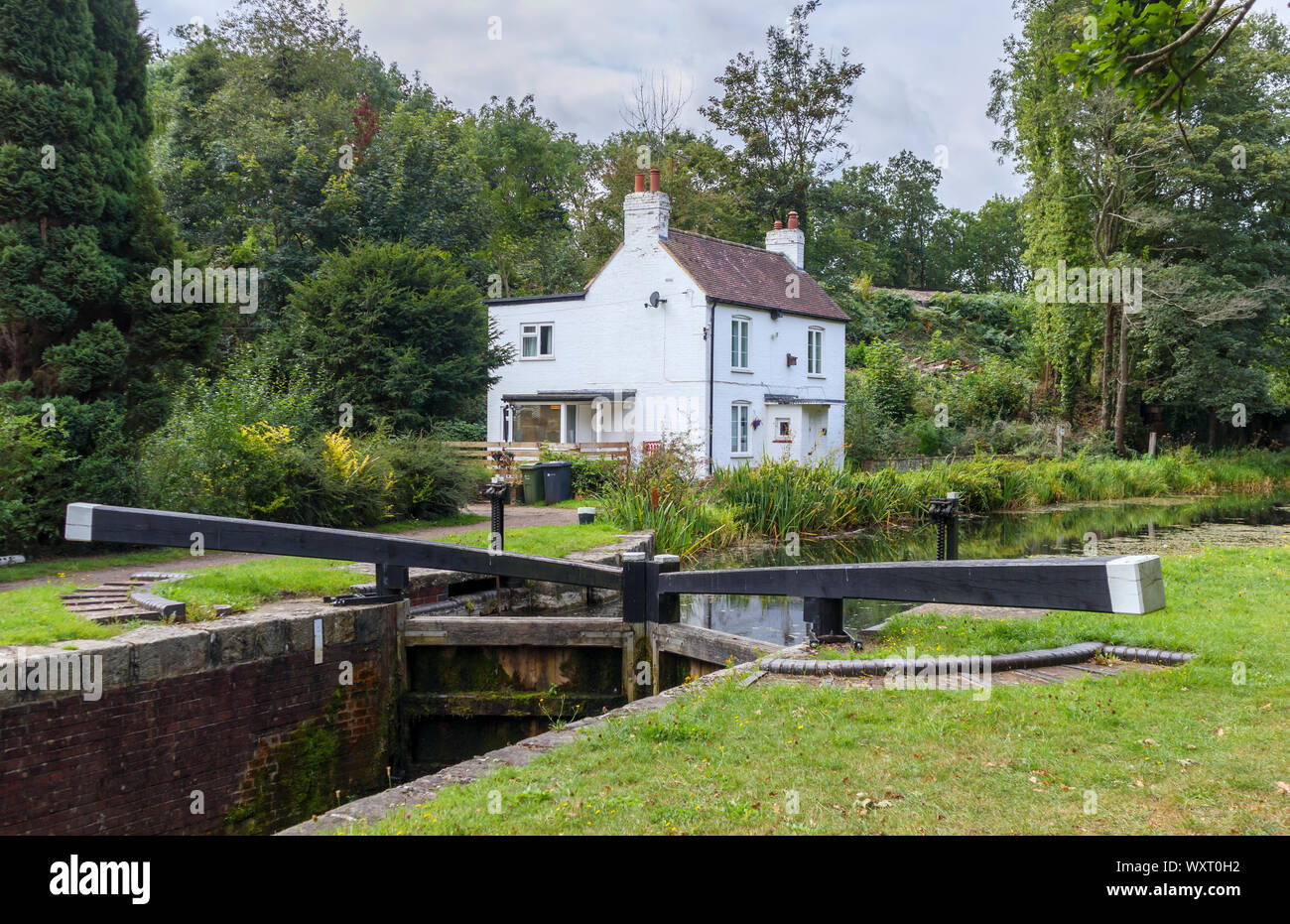 La vecchia serratura keeper's Cottage e cancelletto bloccare sulle rive del Basingstoke Canal in Brookwood, Woking, Surrey, Inghilterra sudorientale, REGNO UNITO Foto Stock
