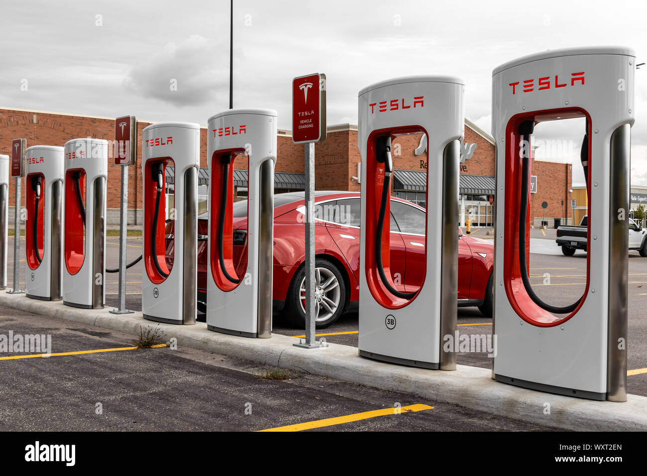 Stazione Supercharger Tesla in un parcheggio all'aperto con ricarica di Tesla Model S. Foto Stock