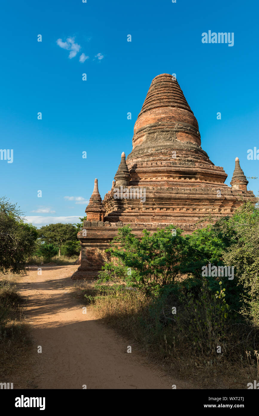 Immagine verticale di strada stretta tra i vecchi templi buddisti di Bagan, una famosa destinazione turistica di Myanmar Foto Stock