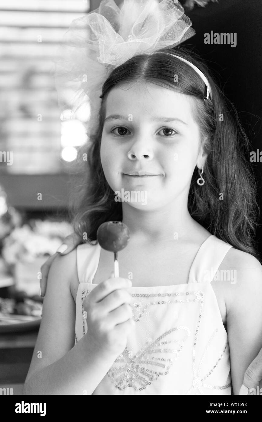 Candy bar e una fetta di torta pop. Alimentazione sana e cheat pasto. Regali per le feste. Dente dolce. Piccola ragazza mangiare round candy. Felice piccolo bambino amore dolci e delizie. Negozio di dolciumi. Piccola ragazza caramelle. Foto Stock