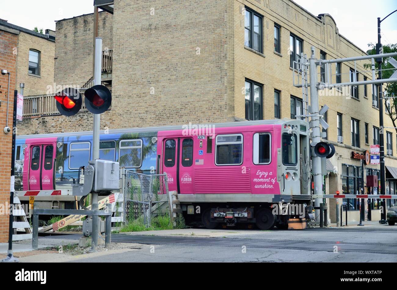 Chicago, Illinois, Stati Uniti d'America. Un colorfully nominato CTA linea marrone treno a transito rapido in esecuzione a livello della strada vicino al suo punto terminale. Foto Stock