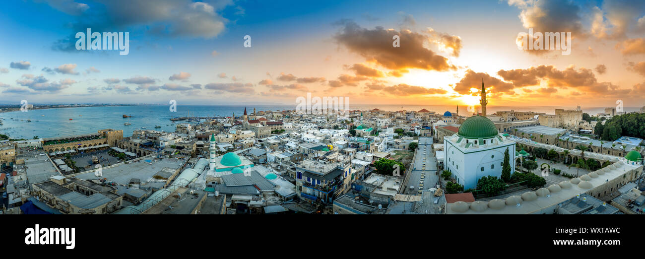 Antenna vista al tramonto di Acco centro storico medievale con Al Jazzar mosque crusader e ottomano mura, bazaar arabi e cielo arancione Foto Stock