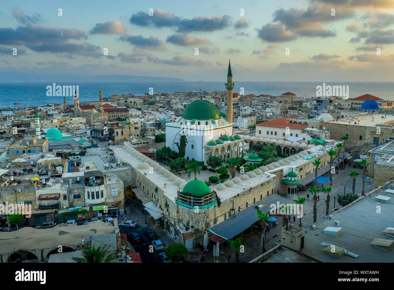 Antenna vista al tramonto di Acco centro storico medievale con Al Jazzar mosque crusader e ottomano mura, bazaar arabi e cielo arancione Foto Stock