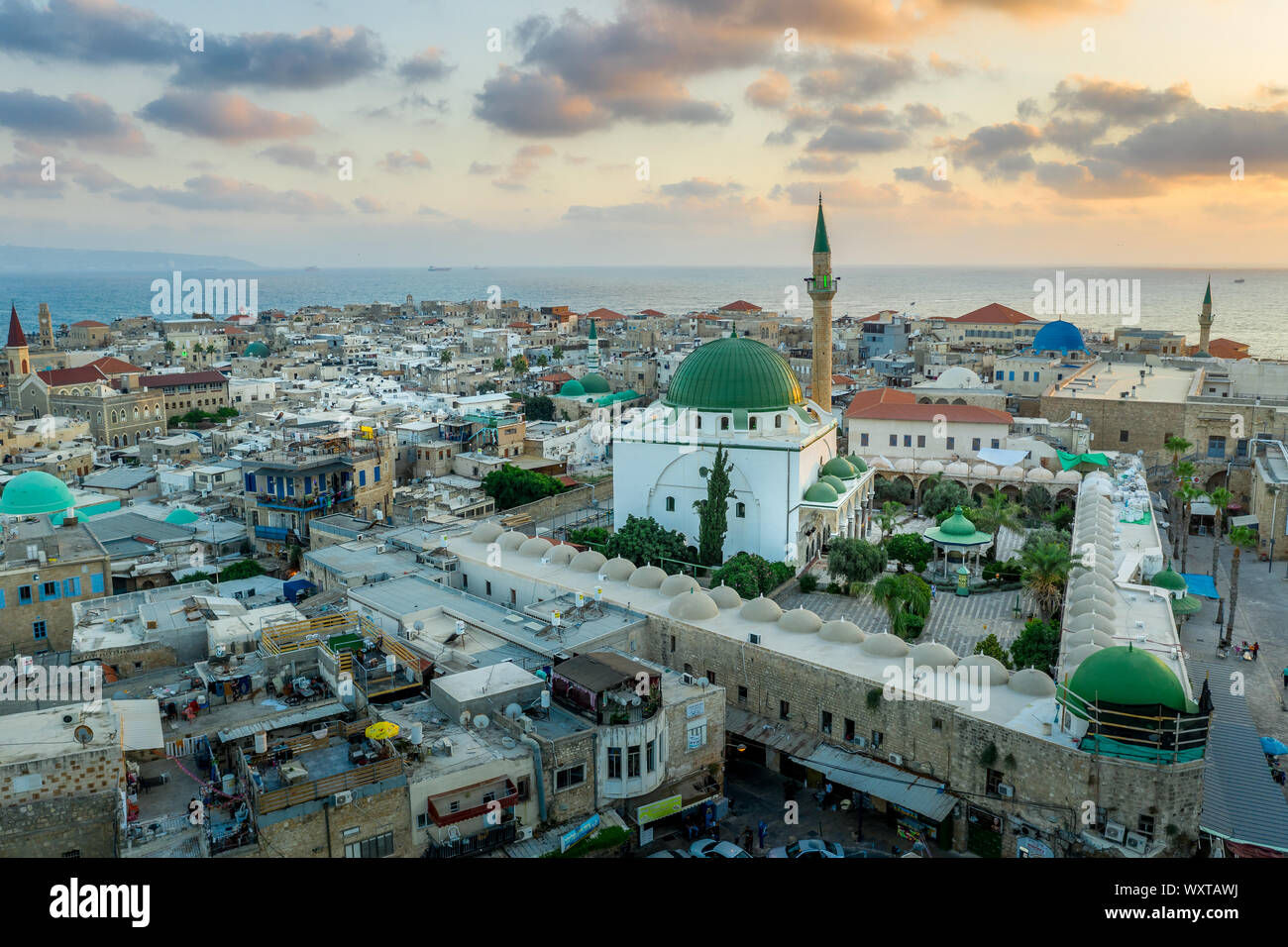 Antenna vista al tramonto di Acco centro storico medievale con Al Jazzar mosque crusader e ottomano mura, bazaar arabi e cielo arancione Foto Stock