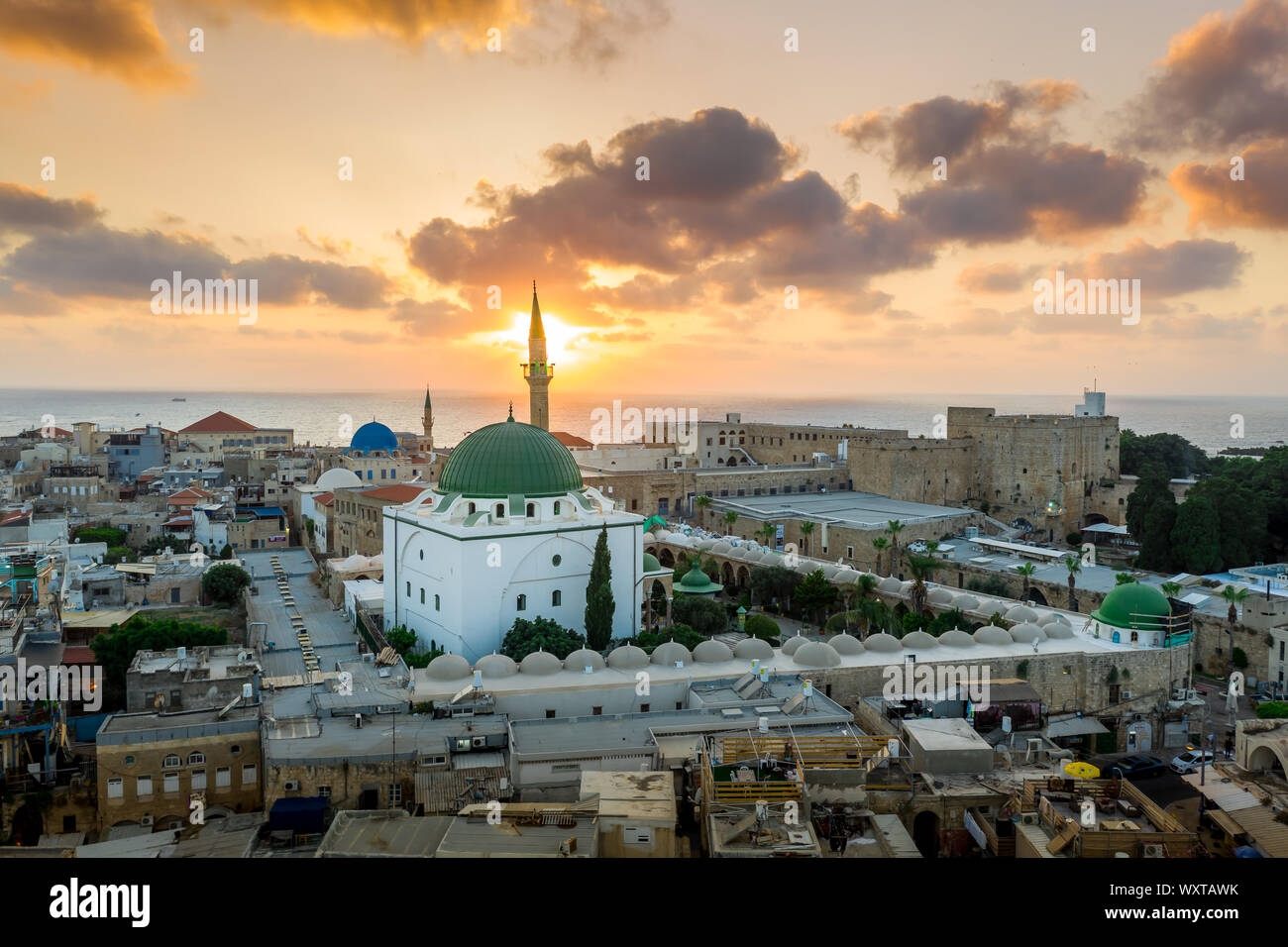 Antenna vista al tramonto di Acco centro storico medievale con Al Jazzar mosque crusader e ottomano mura, bazaar arabi e cielo arancione Foto Stock