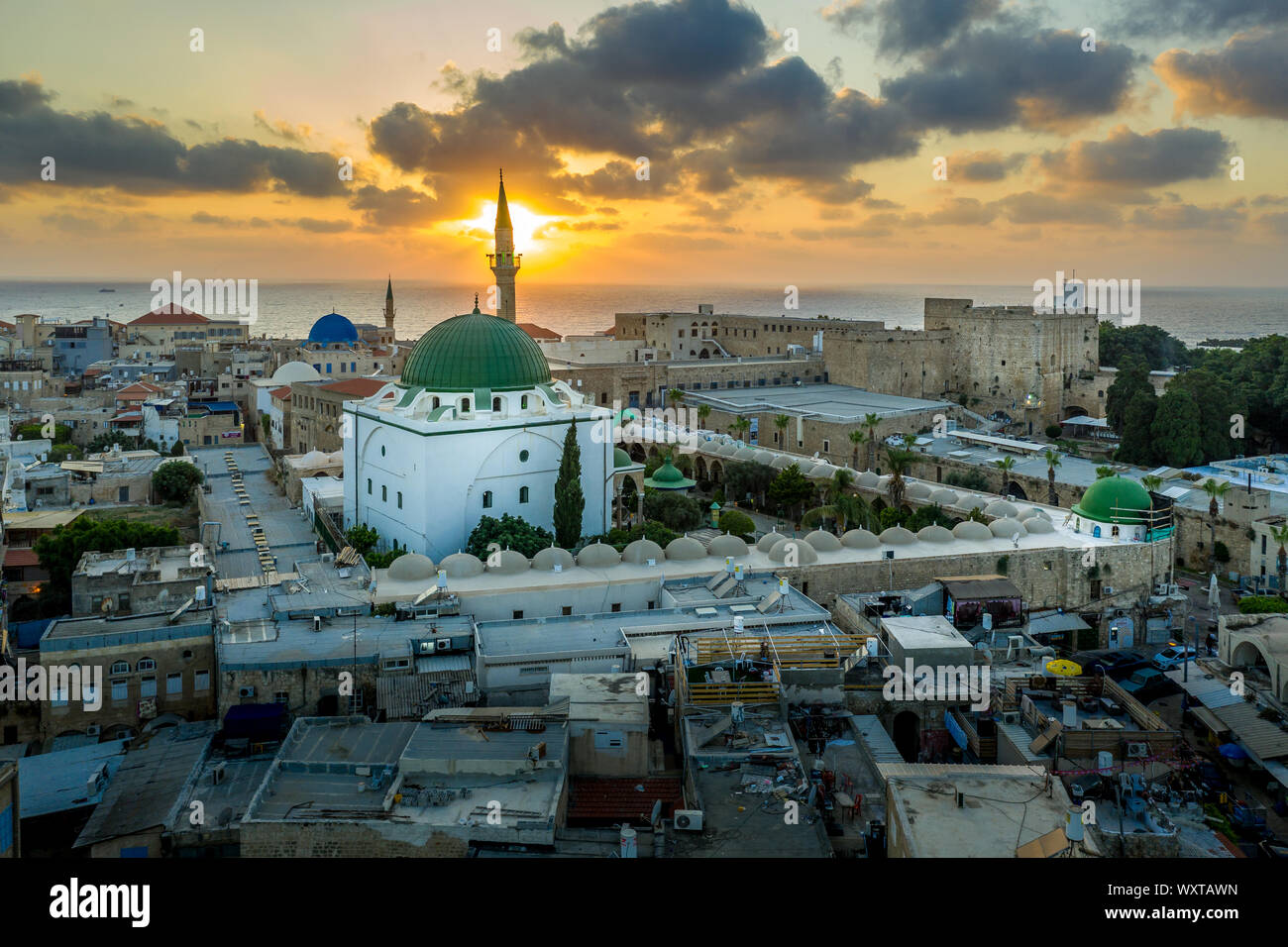 Antenna vista al tramonto di Acco centro storico medievale con Al Jazzar mosque crusader e ottomano mura, bazaar arabi e cielo arancione Foto Stock