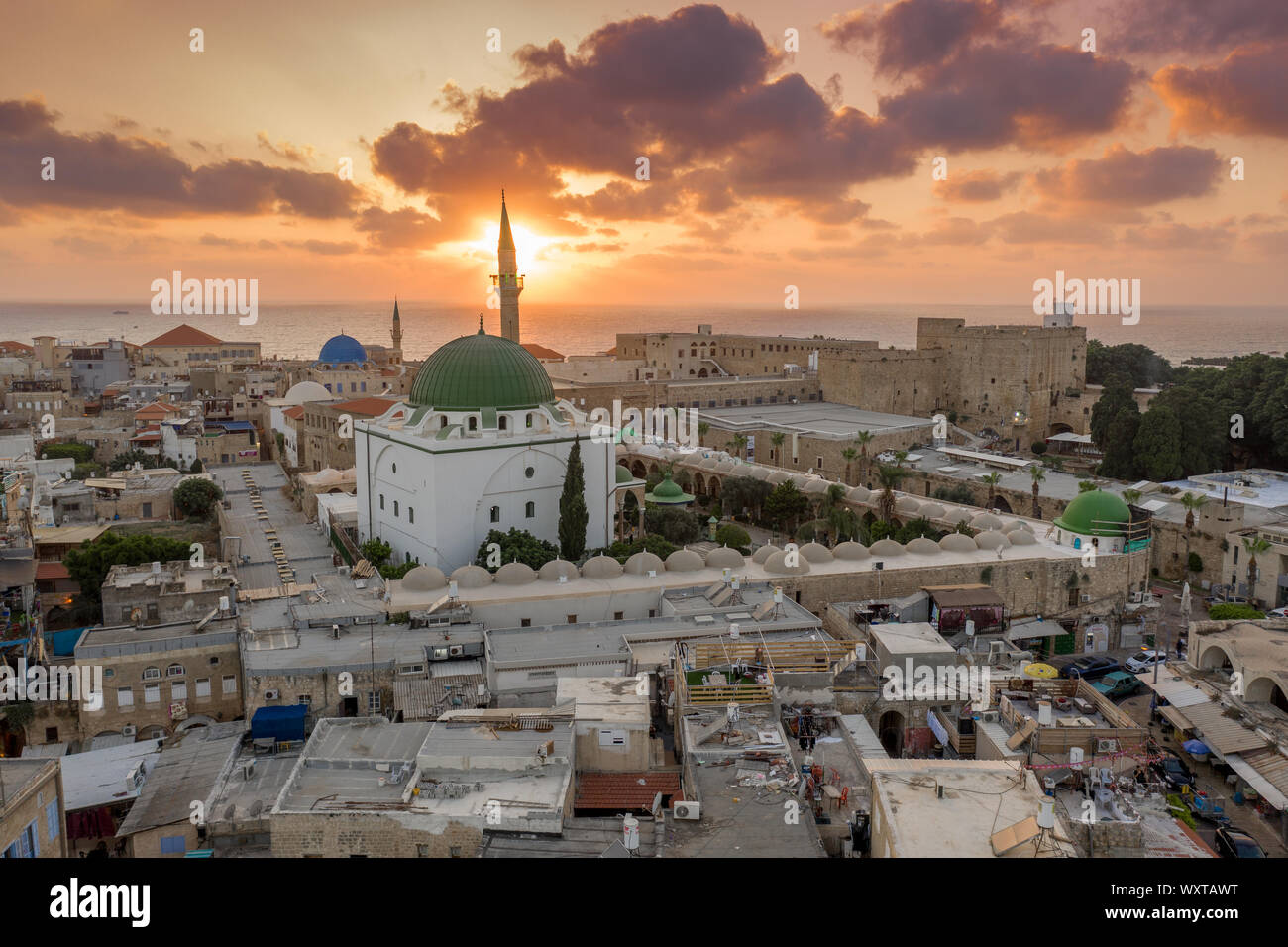 Antenna vista al tramonto di Acco centro storico medievale con Al Jazzar mosque crusader e ottomano mura, bazaar arabi e cielo arancione Foto Stock