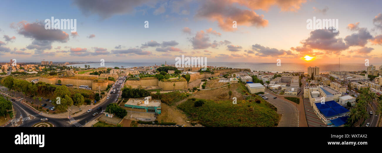 Antenna vista al tramonto di Acco centro storico medievale con Al Jazzar mosque crusader e ottomano mura, bazaar arabi e cielo arancione Foto Stock