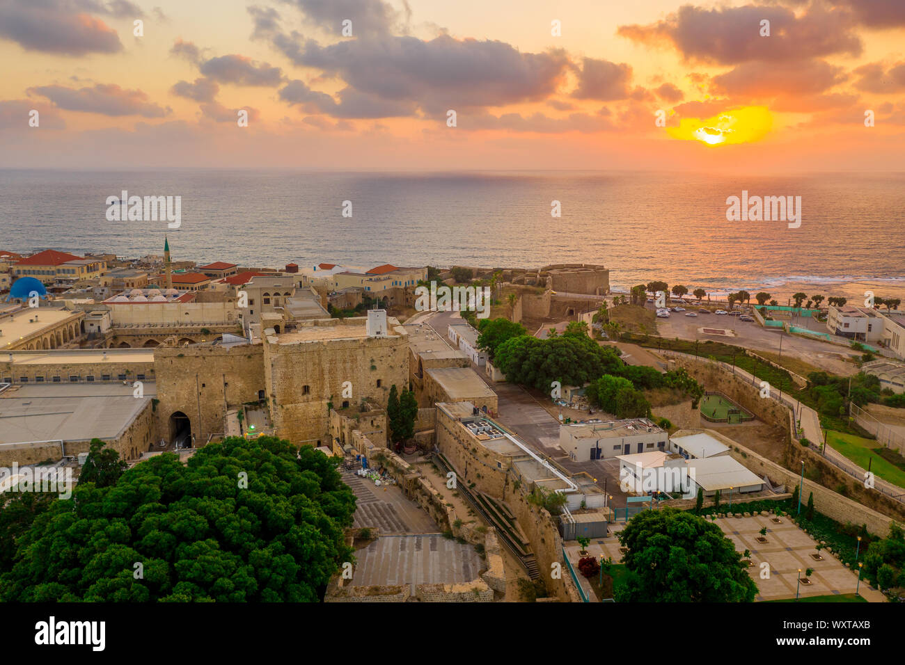 Antenna vista al tramonto di Acco centro storico medievale con Al Jazzar mosque crusader e ottomano mura, bazaar arabi e cielo arancione Foto Stock