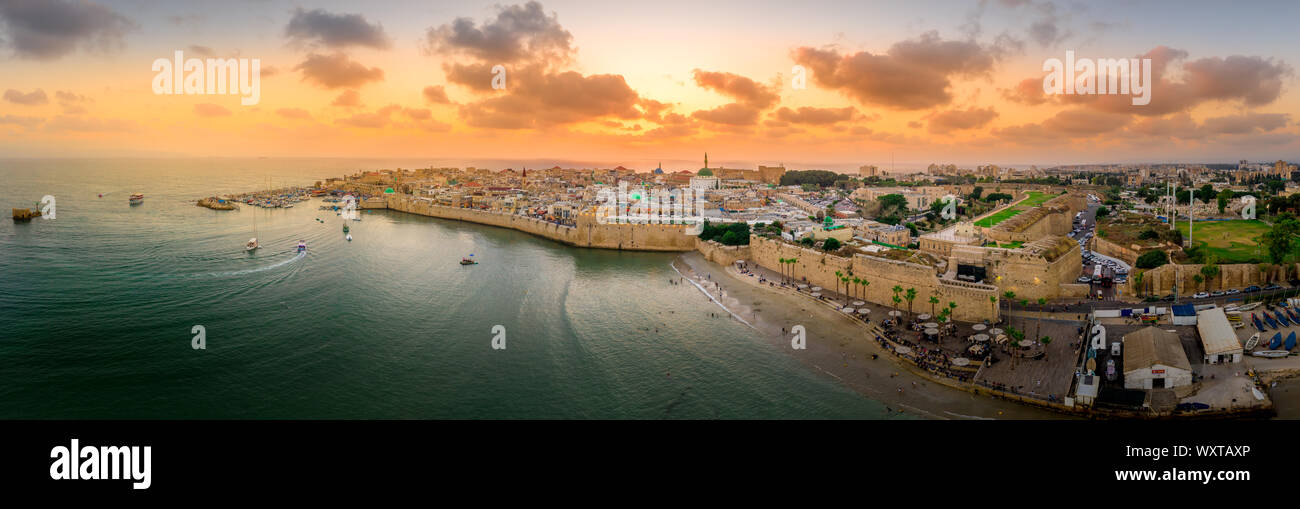 Antenna vista al tramonto di Acco centro storico medievale con Al Jazzar mosque crusader e ottomano mura, bazaar arabi e cielo arancione Foto Stock
