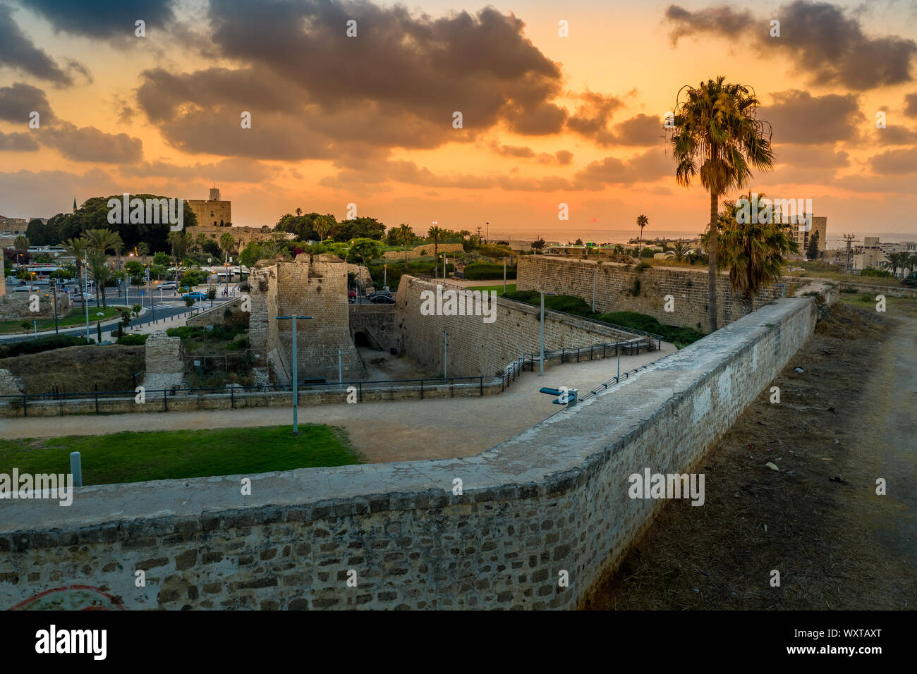 Antenna vista al tramonto di Acco centro storico medievale con Al Jazzar mosque crusader e ottomano mura, bazaar arabi e cielo arancione Foto Stock
